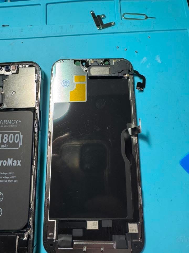 Replacement iPhone display assembly next to the opened phone